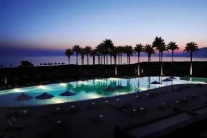 View of the Mediterranean over pool and palm trees at Vedura resort wedding.
