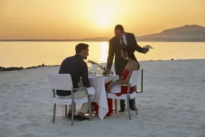 Couple enjoy a romantic dinner on a white sand beach in Sicily.